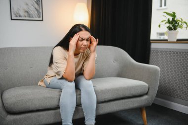 Alnına dokunan üzgün, yorgun, genç bir kadın baş ağrısı ya da depresyon geçiriyor. Sıkıntılı, sıkıntılı bir kız.