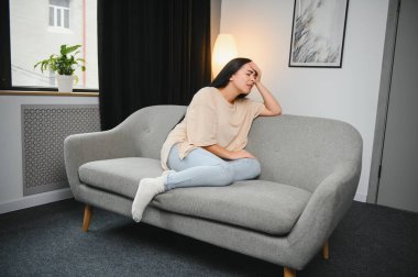 Alnına dokunan üzgün, yorgun, genç bir kadın baş ağrısı ya da depresyon geçiriyor. Sıkıntılı, sıkıntılı bir kız.