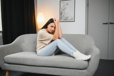 Üzgün kadın iş veya ilişkiler ile sorun, kanepede oturan, dizlerinin kucaklayan, el kapalı yüz, umutsuzluk ve anksiyete, yalnızlık, psikolojik sorun yaşıyorsanız hissi ile hayal kırıklığına