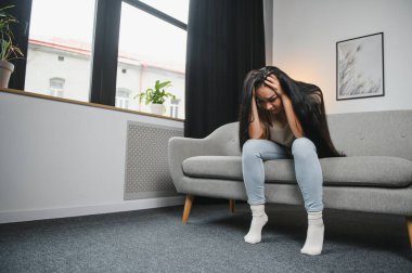 Üzgün kadın iş veya ilişkiler ile sorun, kanepede oturan, dizlerinin kucaklayan, el kapalı yüz, umutsuzluk ve anksiyete, yalnızlık, psikolojik sorun yaşıyorsanız hissi ile hayal kırıklığına