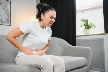 Genç kadın evde karın ağrısı muzdarip. Kadın hastalıkları kavramı.