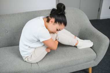 Genç kadın evde karın ağrısı muzdarip. Kadın hastalıkları kavramı.