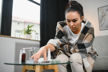 Evde koltukta oturan genç hasta kadın