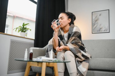 Evde koltukta oturan genç hasta kadın