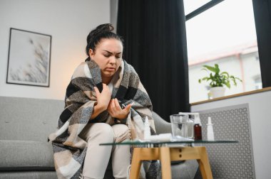 Evde koltukta oturan genç hasta kadın