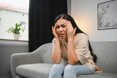 Alnına dokunan üzgün, yorgun, genç bir kadın baş ağrısı ya da depresyon geçiriyor. Sıkıntılı, sıkıntılı bir kız.