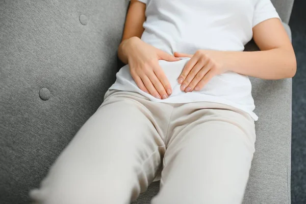 Aylık adet, adet döngüsü günü, genç bir kadın, karın ağrısı çeken bir kadın, adet öncesi, karın ağrısı ya da karın ağrısı çekiyor. Vücuttaki sağlık sorunu iltihaplandı