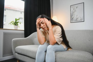 Alnına dokunan üzgün, yorgun, genç bir kadın baş ağrısı ya da depresyon geçiriyor. Sıkıntılı, sıkıntılı bir kız.