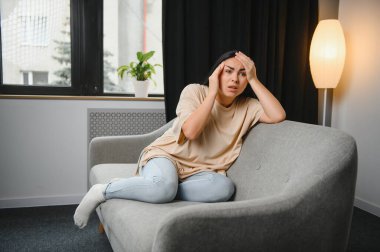 Alnına dokunan üzgün, yorgun, genç bir kadın baş ağrısı ya da depresyon geçiriyor. Sıkıntılı, sıkıntılı bir kız.