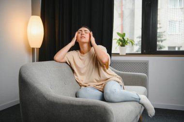 Alnına dokunan üzgün, yorgun, genç bir kadın baş ağrısı ya da depresyon geçiriyor. Sıkıntılı, sıkıntılı bir kız.