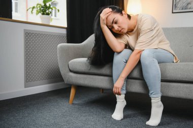 Üzgün, üzgün, çekici bir kadın evdeki kanepede ağlıyor. Yalnız hissediyor, yorgun ve endişeli. Akıl sağlığı, yalnızlık ve yalnızlık yüzünden depresyonda. Psikoloji, yalnızlık ve insanlar