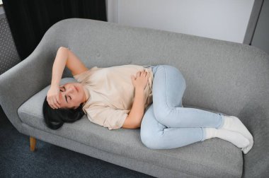 Aylık adet, adet döngüsü günü, genç bir kadın, karın ağrısı çeken bir kadın, adet öncesi, karın ağrısı ya da karın ağrısı çekiyor. Vücuttaki sağlık sorunu iltihaplandı