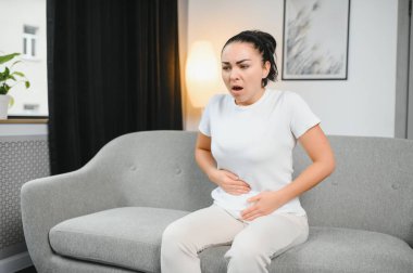 Genç kadın evde karın ağrısı muzdarip. Kadın hastalıkları kavramı.