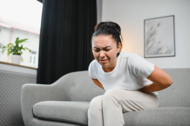 Genç kadın evde karın ağrısı muzdarip. Kadın hastalıkları kavramı.