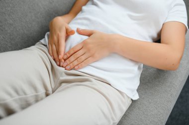 Aylık adet, adet döngüsü günü, genç bir kadın, karın ağrısı çeken bir kadın, adet öncesi, karın ağrısı ya da karın ağrısı çekiyor. Vücuttaki sağlık sorunu iltihaplandı