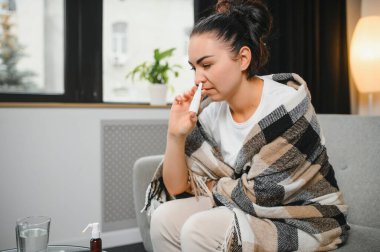 Evde burun spreyi kullanan hasta bir kadın..