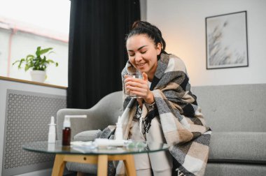 Evde koltukta oturan genç hasta kadın