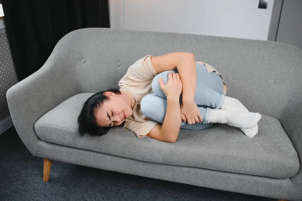 Aylık adet, adet döngüsü günü, genç bir kadın, karın ağrısı çeken bir kadın, adet öncesi, karın ağrısı ya da karın ağrısı çekiyor. Vücuttaki sağlık sorunu iltihaplandı