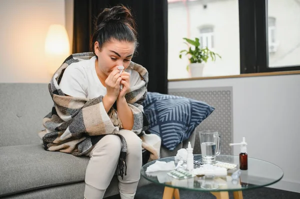 Sağlık hizmeti, soğuk algınlığı, alerji ve insanlar konsepti. Hasta kadın, evdeki kağıt mendile burnunu siliyor.