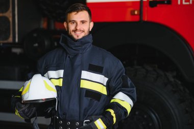 İtfaiyeci (itfaiye) eylem daimi bir firetruck yakınındaki. Acil durum Emanet. Koruma, tehlikeden kurtarmak
