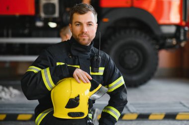 İtfaiyeci (itfaiye) eylem daimi bir firetruck yakınındaki. Acil durum Emanet. Koruma, tehlikeden kurtarmak