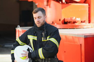 İtfaiyeci (itfaiye) eylem daimi bir firetruck yakınındaki. Acil durum Emanet. Koruma, tehlikeden kurtarmak