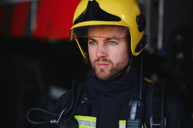 İtfaiyeci (itfaiye) eylem daimi bir firetruck yakınındaki. Acil durum Emanet. Koruma, tehlikeden kurtarmak