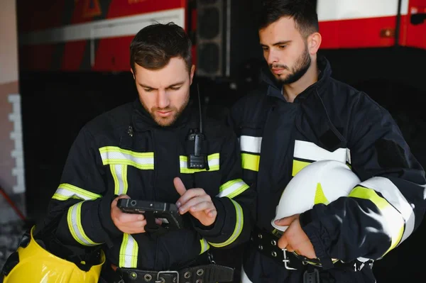 两名消防员在消防行动中的画像 身穿防护服的消防员和使用平板电脑作战的头盔的画像 — 图库照片