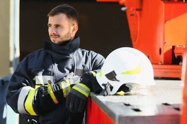 İtfaiyeci (itfaiye) eylem daimi bir firetruck yakınındaki. Acil durum Emanet. Koruma, tehlikeden kurtarmak