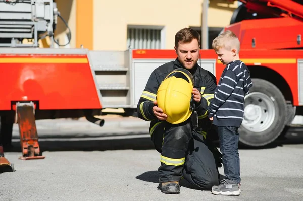 勇敢な心で危険な人々を保護します 煙を燃やすから均一な安全な子供を持つ消防士のヒーロー — ストック写真