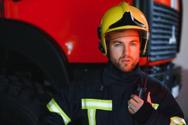 İtfaiyeci (itfaiye) eylem daimi bir firetruck yakınındaki. Acil durum Emanet. Koruma, tehlikeden kurtarmak