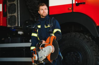 İtfaiyeci (itfaiye) eylem daimi bir firetruck yakınındaki. Acil durum Emanet. Koruma, tehlikeden kurtarmak