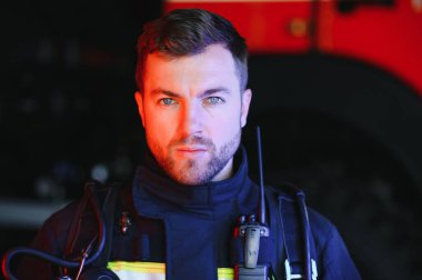 İtfaiyeci (itfaiye) eylem daimi bir firetruck yakınındaki. Acil durum Emanet. Koruma, tehlikeden kurtarmak