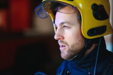 İtfaiyeci (itfaiye) eylem daimi bir firetruck yakınındaki. Acil durum Emanet. Koruma, tehlikeden kurtarmak