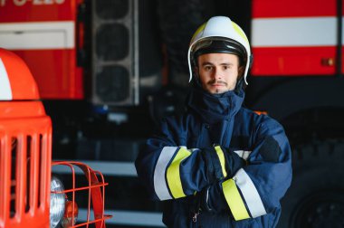 İtfaiyeci (itfaiye) eylem daimi bir firetruck yakınındaki. Acil durum Emanet. Koruma, tehlikeden kurtarmak