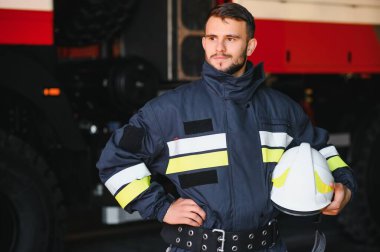 İtfaiyeci (itfaiye) eylem daimi bir firetruck yakınındaki. Acil durum Emanet. Koruma, tehlikeden kurtarmak