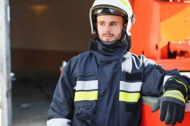 İtfaiyeci (itfaiye) eylem daimi bir firetruck yakınındaki. Acil durum Emanet. Koruma, tehlikeden kurtarmak