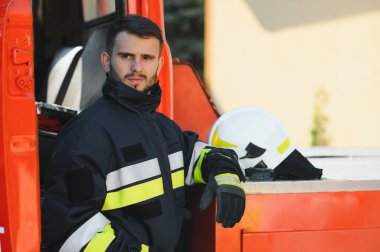 İtfaiyeci (itfaiye) eylem daimi bir firetruck yakınındaki. Acil durum Emanet. Koruma, tehlikeden kurtarmak
