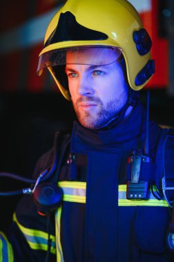 İtfaiyeci (itfaiye) eylem daimi bir firetruck yakınındaki. Acil durum Emanet. Koruma, tehlikeden kurtarmak