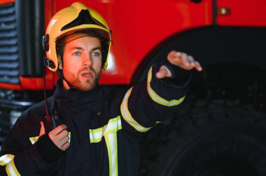 İtfaiyeci (itfaiye) eylem daimi bir firetruck yakınındaki. Acil durum Emanet. Koruma, tehlikeden kurtarmak