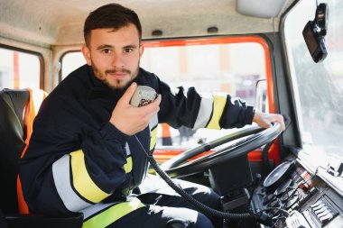 İtfaiyeci itfaiye aracında taşınabilir radyo kullanıyor, mesaj için yer var..