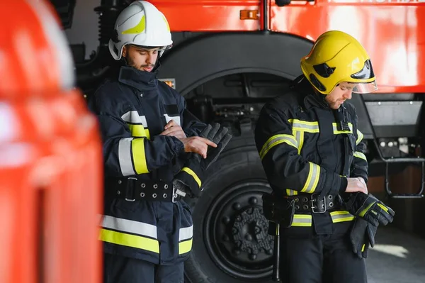 两名身穿防护服 头戴头盔的英勇消防员的画像 — 图库照片