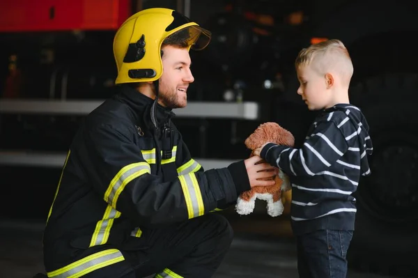 Petugas Pemadam Kebakaran Yang Kotor Memegang Seragam Bocah Yang Terselamatkan — Stok Foto