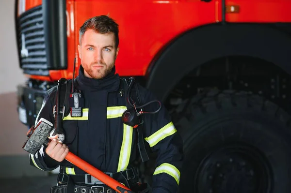 Foto Pemadam Kebakaran Muda Dengan Palu Besar Tangan Dekat Mesin — Stok Foto