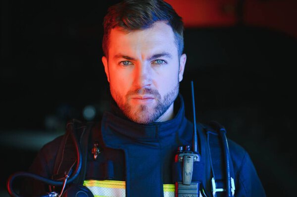 Firefighter portrait on duty. Photo fireman with gas mask and helmet near fire engine