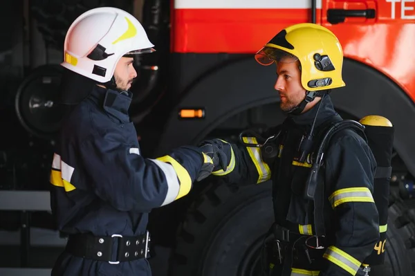 两名身着防护服 头戴消防车 友善握手的消防员 — 图库照片
