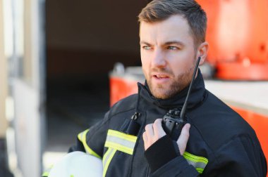 İtfaiyeci (itfaiye) eylem daimi bir firetruck yakınındaki. Acil durum Emanet. Koruma, tehlikeden kurtarmak