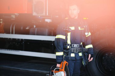 İtfaiyeci (itfaiye) eylem daimi bir firetruck yakınındaki. Acil durum Emanet. Koruma, tehlikeden kurtarmak