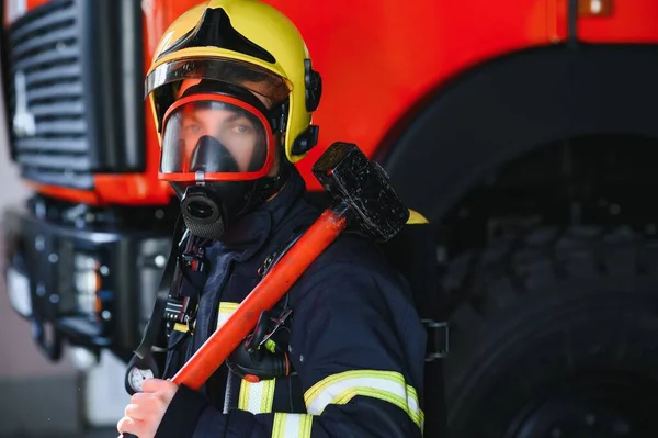 Foto Van Jonge Brandweerman Met Moker Handen Buurt Van Brandweerwagen — Stockfoto