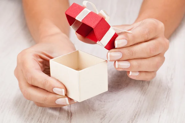 Female hands open a little gift — Stock Photo, Image